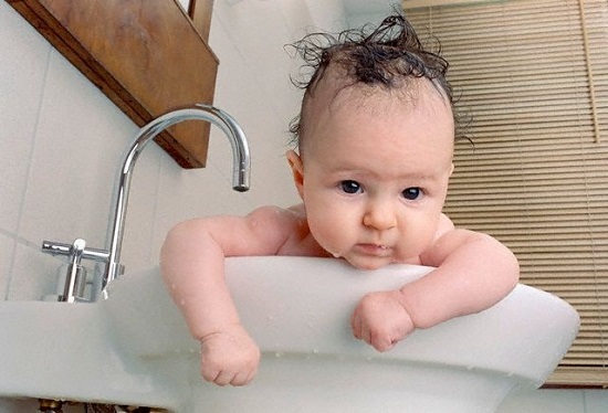Baby Girl Taking Bath in Sink --- Image by © Michael Hagedorn/zefa/Corbis